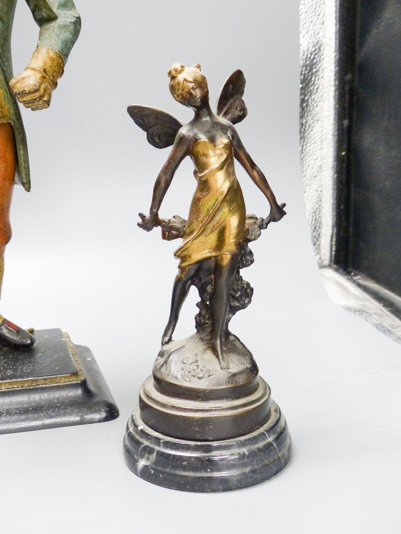 A painted cast iron figure all mantle timepiece and a pair of bronze figures of fairies, tallest 40 cm high